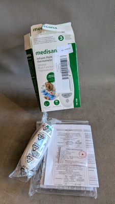 une boîte de médicaments et une brosse à dents posées sur un canapé