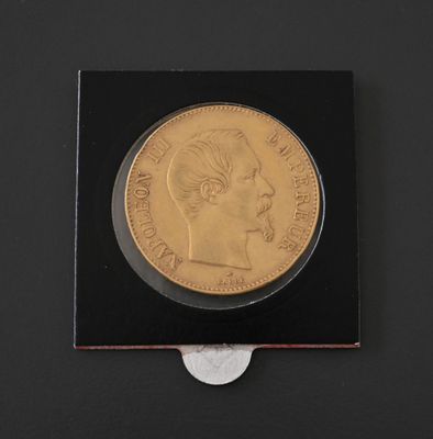 a close up of a coin on a black surface with a coin in front of it