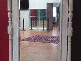 un miroir posé sur un pied dans une pièce aux murs rouges