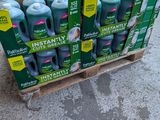 Plusieurs bouteilles de Deteré sont empilées sur une palette dans un parking.