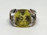 une image représentant une bague ornée d'une pierre jaune sur un fond blanc