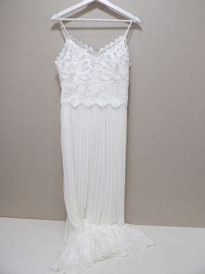 une robe de mariée blanche suspendue à un cintre accroché au mur