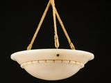 un bol en verre blanc suspendu à une corde sur fond noir