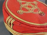 a red and black hat with a gold emblem on it