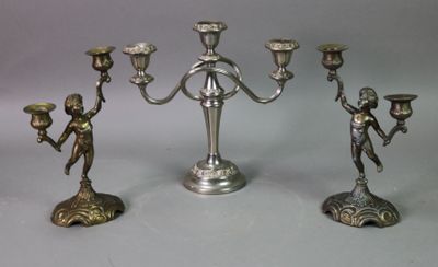 three silver colored candlesticks sitting next to each other on a table