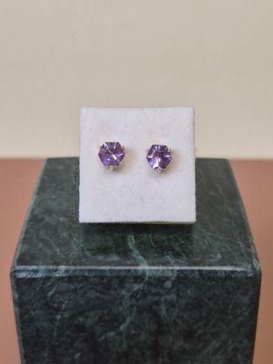 une paire de boucles d'oreilles en améthorate posée sur un bloc de marbre