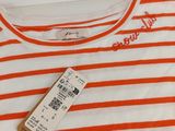 an orange and white striped t - shirt with a tag on it