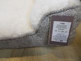a dog bed with a tag on it sitting on a table