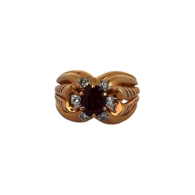 gros plan d'une bague en or avec une pierre rouge
