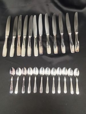 a lot of silver spoons and knives on the table