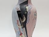 un vase avec un tableau posé sur une table