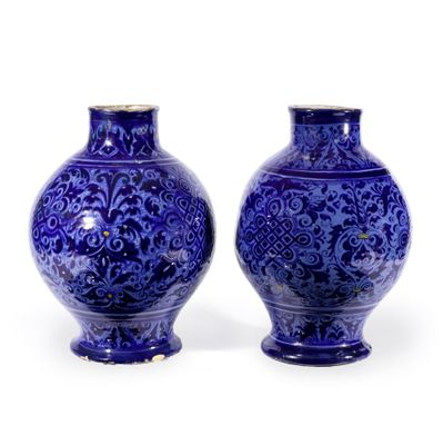 deux vases bleus posés l'un à côté de l'autre sur une surface blanche