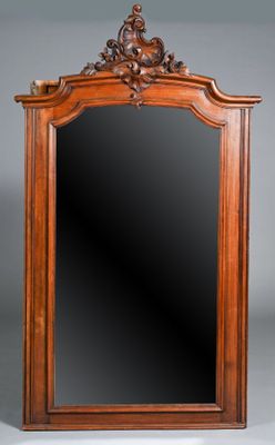 an antique wooden mirror with a carved frame