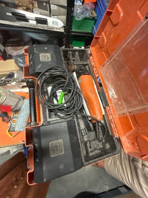 une boîte orange contenant des outils, posée sur une table