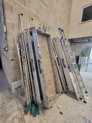 plusieurs échelles appuyées contre un mur dans un immeuble