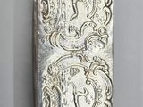 a close up of a silver pill case with a design on it