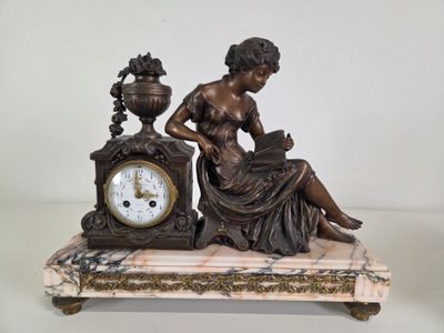 a statue of a woman sitting on a table with a clock