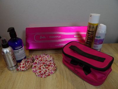 a pink bag sitting on top of a table next to a bottle of lotion