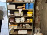 a shelf of paint and other items in a room