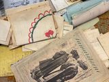 a pile of old papers on the floor next to a pile of old books