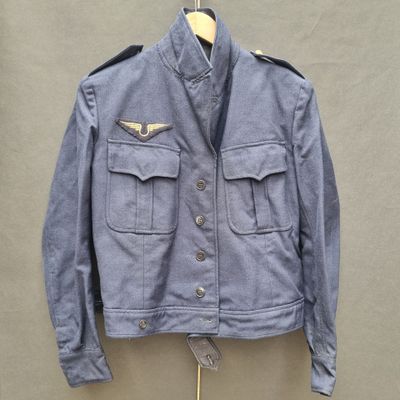 an old blue jacket hanging on a hanger on a wall