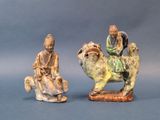two figurines of a man on a camel and a man on a horse