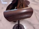a wooden object on a marble table with a baseball glove on it