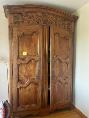 a large wooden armoire in the corner of a room