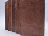 five books lined up in a row on a white surface