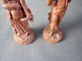 two figurines of a man and a woman sitting on a chair
