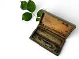 a small wooden box with a green leaf on it