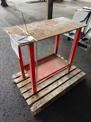 une petite table avec un plateau rouge posée sur une palette en bois