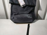 a black backpack with a tag on it sitting on a table
