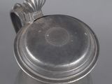 an antique silverplated teapot with a lid on a table