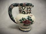 a white vase with a floral design on it