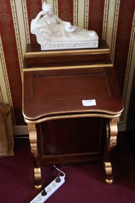 une petite table sur laquelle se trouve une statue, à côté d'une télécommande