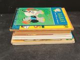 several children ' s books stacked on top of each other on a table