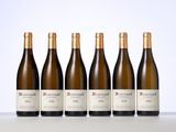 six bottles of wine are lined up on a table