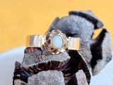 une bague en or surmontée d'une pierre blanche