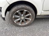 une voiture blanche qui a un pneu crevé sur la route