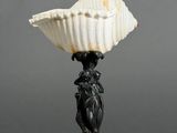 a black and white vase with a shell on top of it