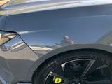 a close up of a black car with a yellow sticker on it