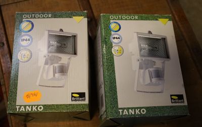 deux cartons contenant des chauffe-eau d'extérieur posés sur une table en bois