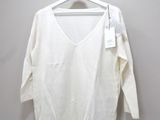 the white shirt is hanging on a hanger on the wall