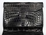 an image of a black crocodile skin purse with a gold clasp
