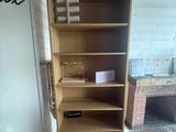 a wooden bookcase in the corner of a room