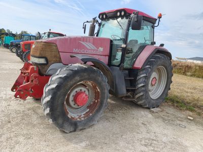un tracteur rouge garé sur le bord de la route