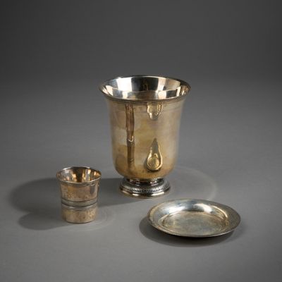 une tasse en argent et une assiette en argent posées sur une table