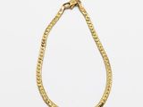 un collier en or avec une chaîne sur fond blanc