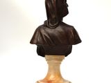 statue of a woman with a hood on her head on a marble base